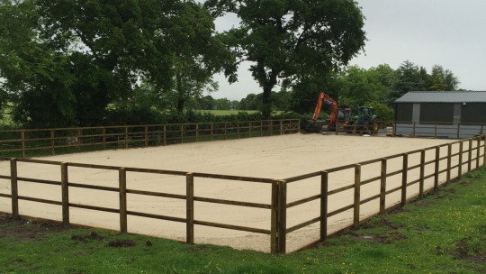 Post and rail fencing installed and layer of equestrian sand