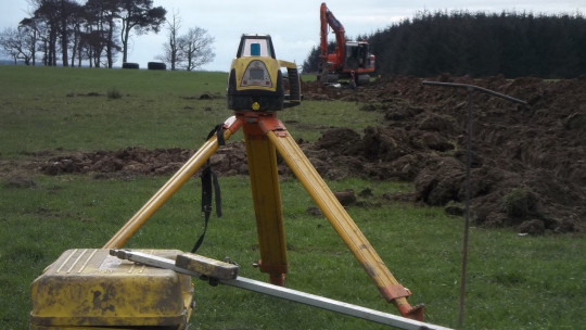 Laser level being used to dig in new leader drains 