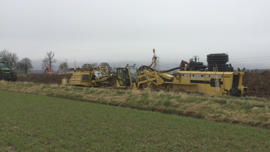 The Inter-Drain laying pipe and being back-filled with a tracked gravel cart