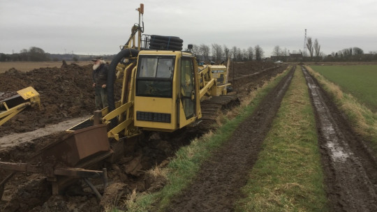 Inter-Drain in the dug out track showing the gravel hopper which drops the stone on top of the laid pipe