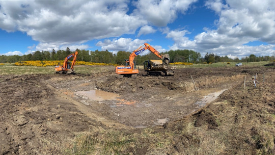 Two diggers and a tracked dumper at work on the farm pond construction