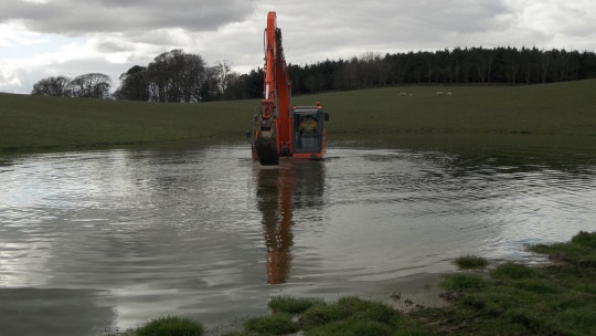 Digging an outlet for the flooded part of the field